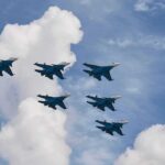 Six fighter jets flying in formation against a blue sky