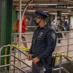 Penn Station Bloodbath – Commuters STABBED! Police officer stands in a subway station near caution tape