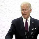 man in suit speaking at a podium