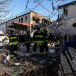 Firefighters assess damage at a collapsed residential building
