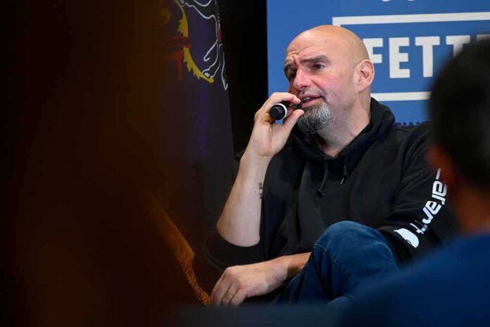 Bald man in a hoodie speaking into a microphone