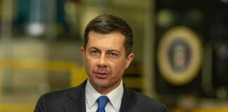 Pete Buttigieg speaking at a podium with microphones