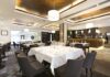 Interior of a modern restaurant with elegantly set tables and a bar area