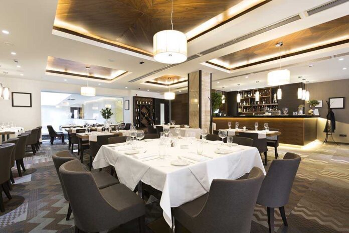 Interior of a modern restaurant with elegantly set tables and a bar area