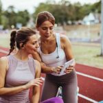 MELTDOWN! Trans Community RAGES Over NBA Players Joining WNBA Two women at a running track looking at a tablet