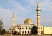 Mosque Meltdown Ignites City Hall Mosque with golden dome and two tall minarets under a partly cloudy sky