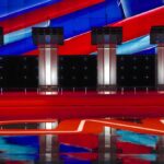 Senate Debate Derailed After Candidate Does UNTHINKABLE Debate stage with four empty podiums and bright red and blue backdrop