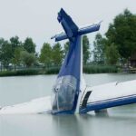 GOP Rep’s Plane Dies Mid-Air, Emergency Water Landing A submerged airplane partially in a lake with trees in the background