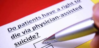 Hand holding pen over a yes or no checkbox on a medical ethics question
