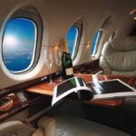 private jet cabin with leather seat, champagne and magazine on table