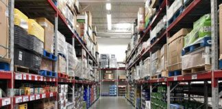 Warehouse aisle with tall shelves stacked with boxes and bulk goods