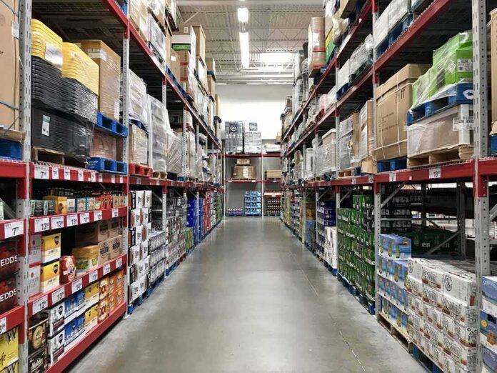 shutterstock_647392279 Warehouse aisle with tall shelves stacked with boxes and bulk goods