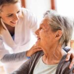 Caregiver smiling at an elderly woman