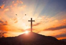 cross on a hill at sunset