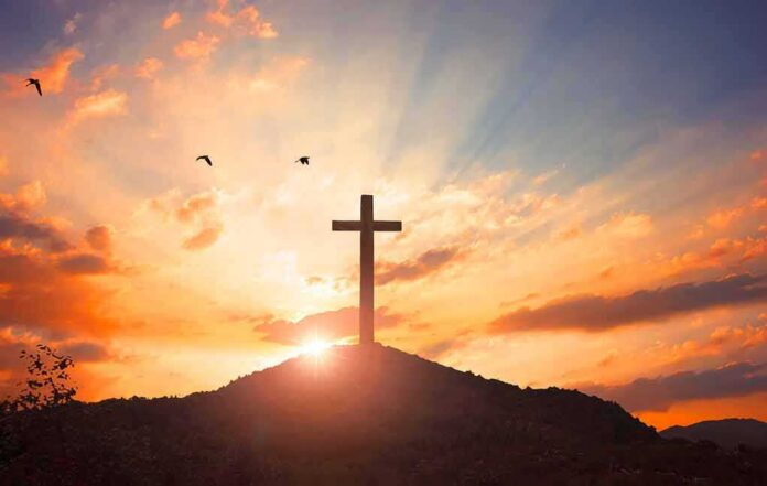 cross on a hill at sunset