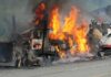 Burning semi-truck cab and trailer on highway