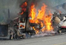 Burning semi-truck cab and trailer on highway