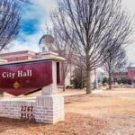City Hall sign in front of a red-brick municipal building