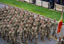 Firing Squad Standoff Shocks The Army Soldiers in camouflage uniforms march in formation on a street