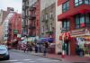 City street with brick buildings, fire escapes, and busy storefronts