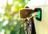 Electric car charging port with plugged-in cable