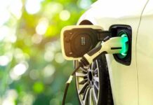 Electric car charging port with plugged-in cable
