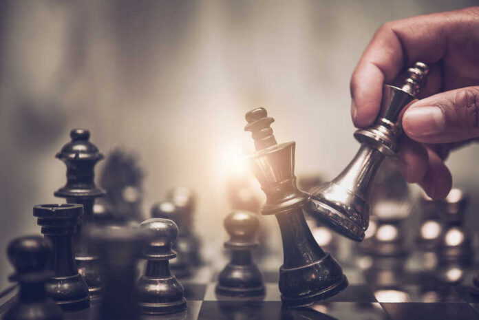 Hand,Of,Businessman,Moving,Chess,Figure,In,Competition,Success,Play.
