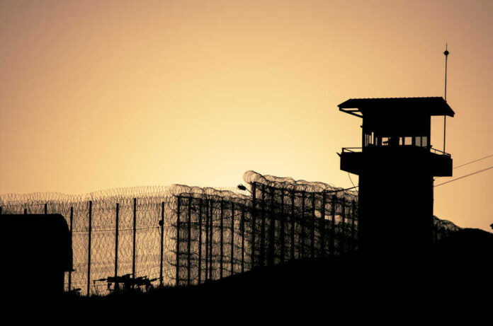 Silhouette,Of,Barbed,Wires,And,Watchtower,Of,Prison,,At,Sunset