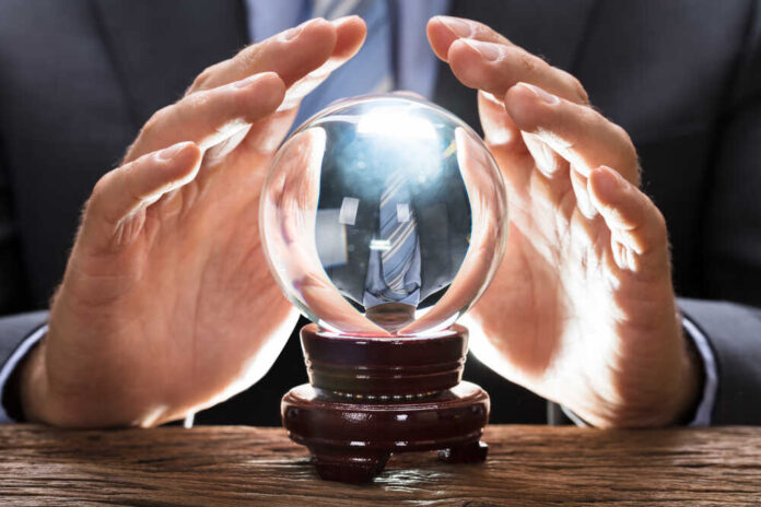 Midsection,Of,Businessman,Covering,Crystal,Ball,At,Wooden,Table