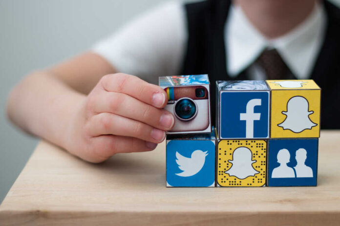 Teenager,Boy,Folds,Cubes,With,The,Logo,Of,Popular,Social
