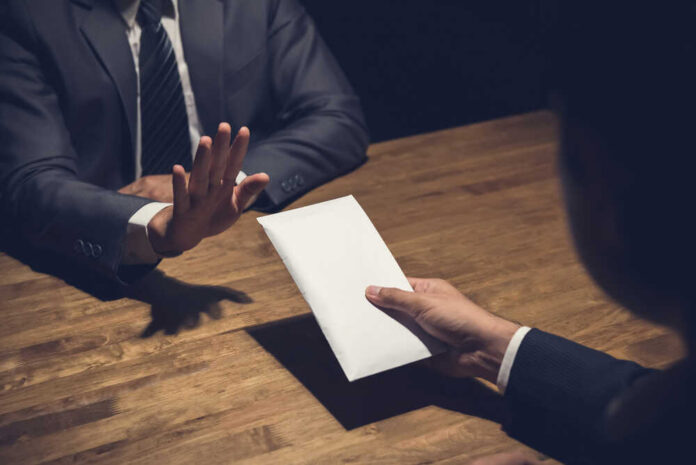 Businessman,Rejecting,Money,In,White,Envelope,Offered,By,His,Partner